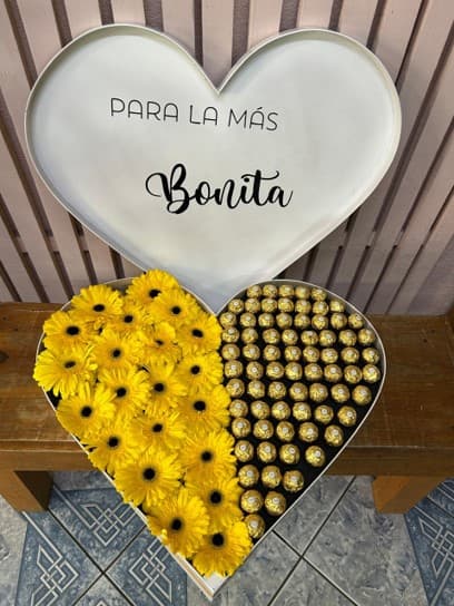 Corazón gigante con tapa y mensaje, con gerberas amarillas y ferreros