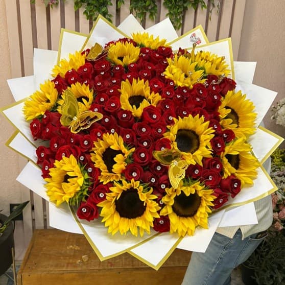 Ramo de 100 rosas rojas con pin de diamantes, 15 girasoles, 1 corona tipo princesa y 2 mariposas